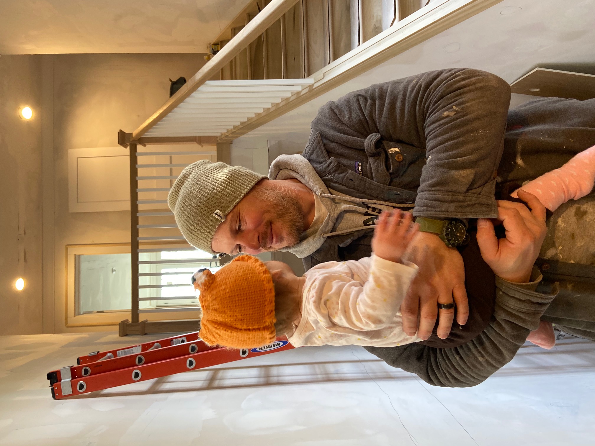 Carson Little holding his daughter Piper on a job site